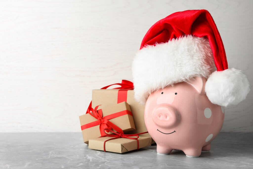 Piggy bank with Santa hat and gift boxes